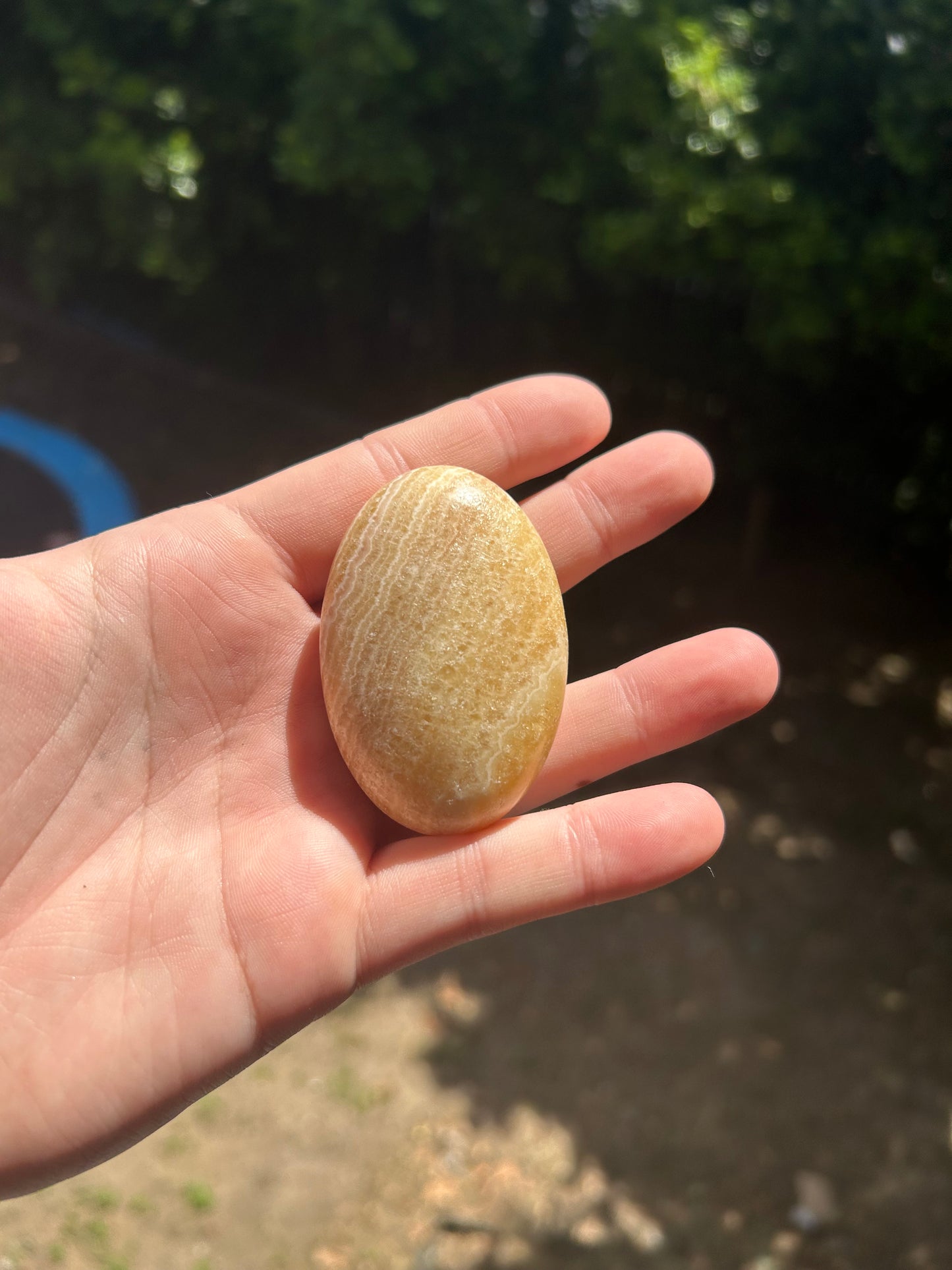 Orange calcite palm stone